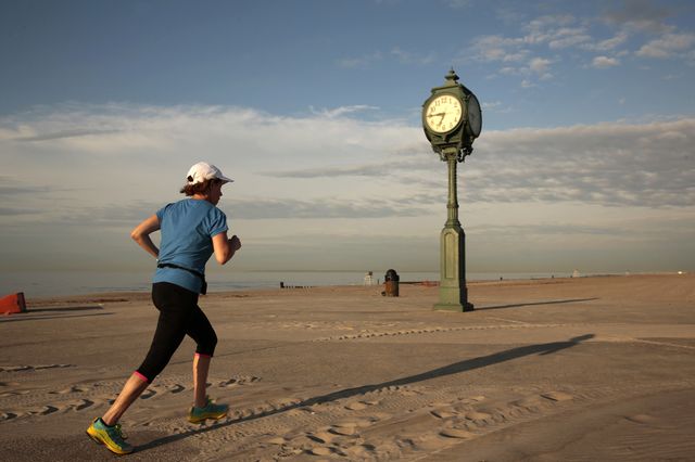 At Gateway National Recreation Area, known as Jacob Riis Park, a woman runs along the path, still covered in sand.